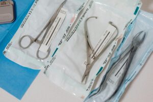 Close-up of sterilized surgical tools in packaging on a clinical table.